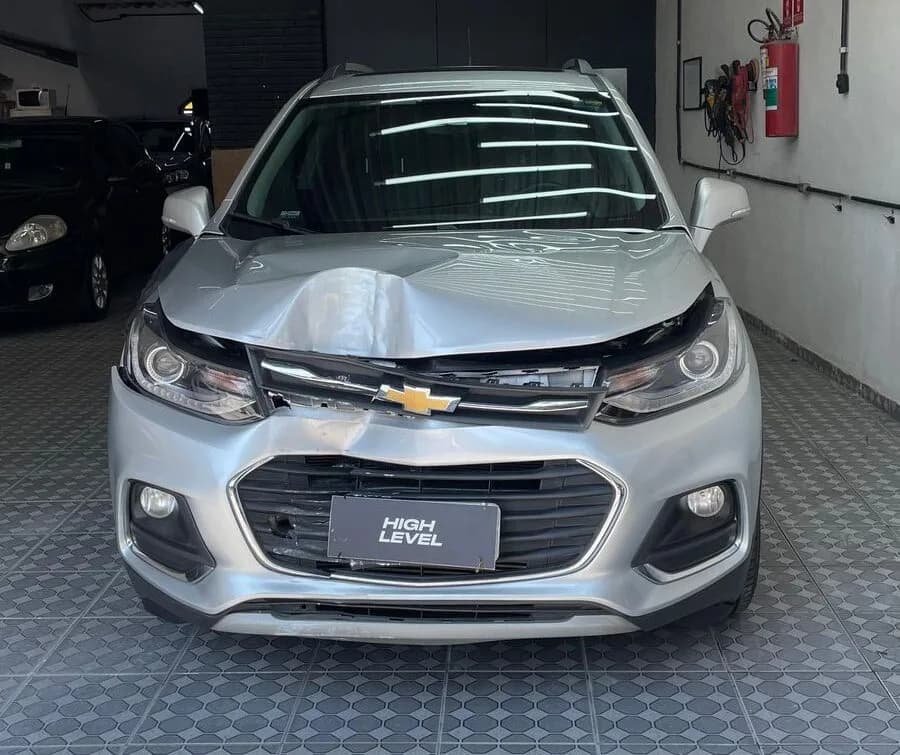 Chevrolet Tracker prata antes do reparo, com capô e para-choque danificados