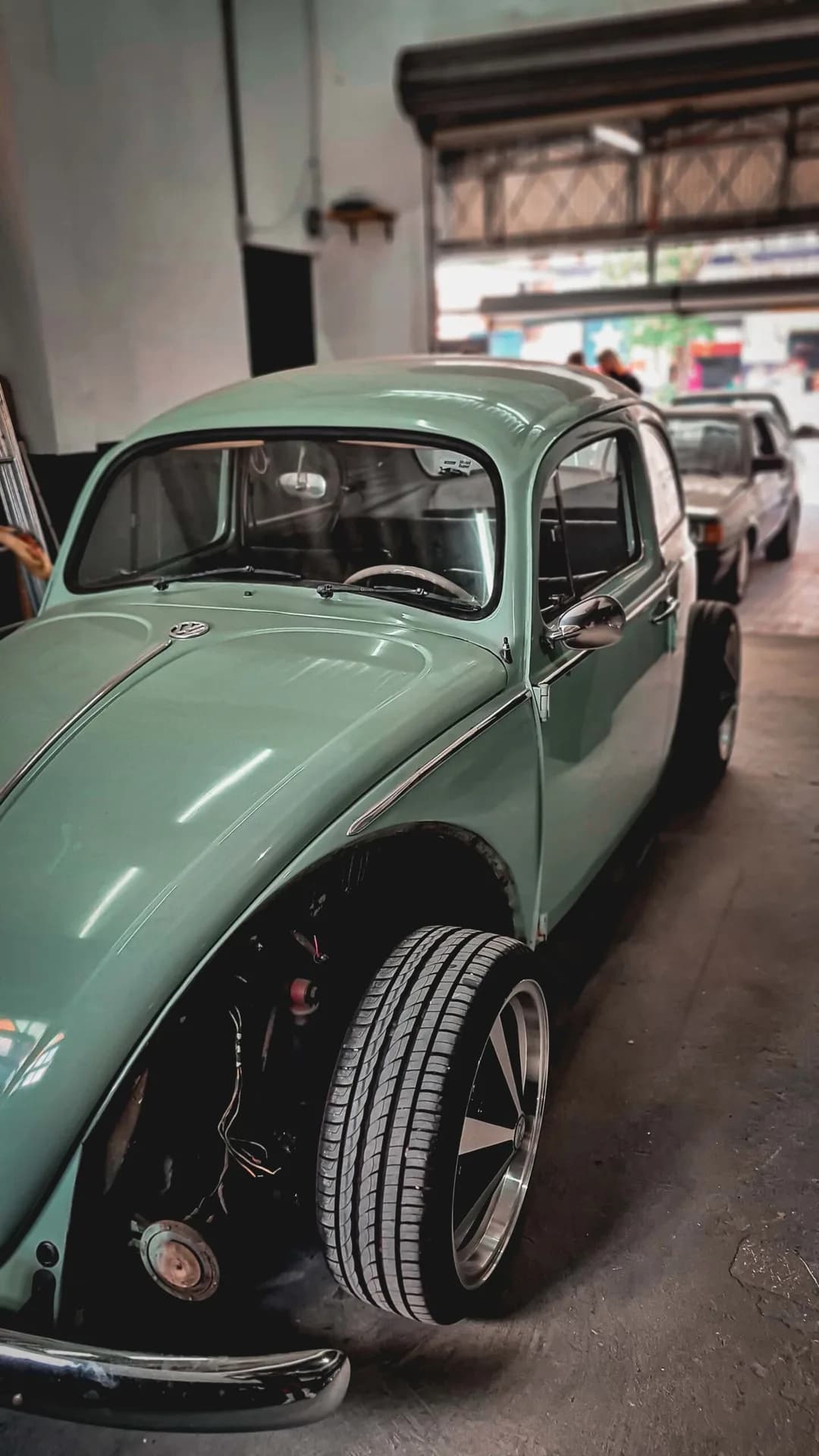 Fusca verde-claro dentro da oficina da High Level